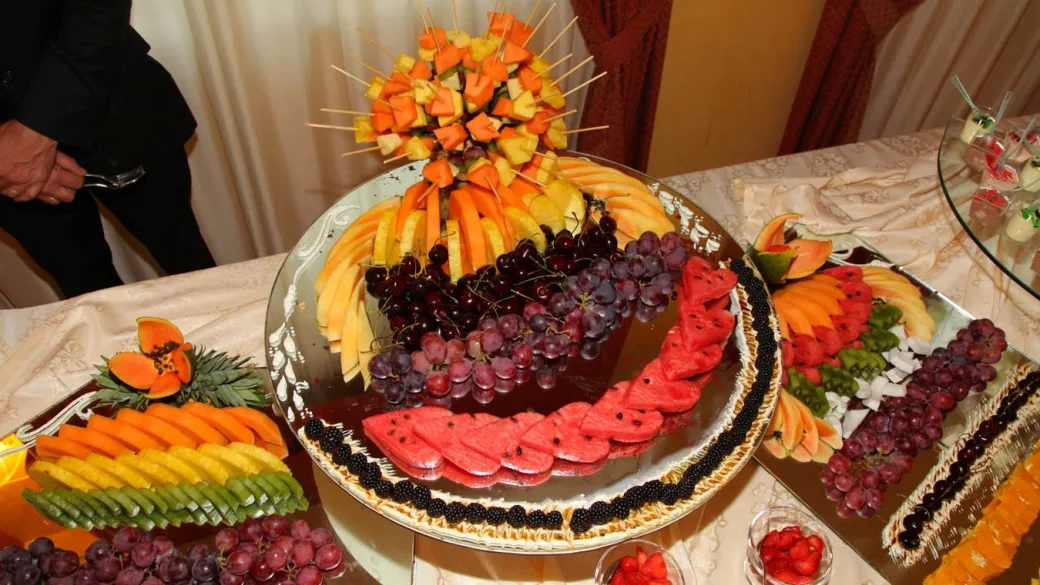 Buffet di frutta fresca decorata con anguria, uva, melone e ananas su tavolo elegante
