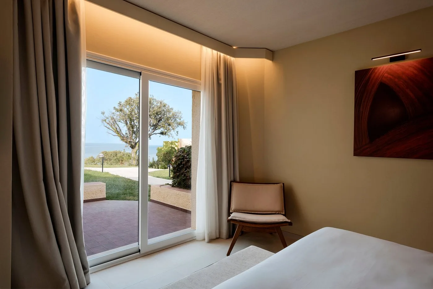 Camera elegante con vetrata vista mare e poltrona
