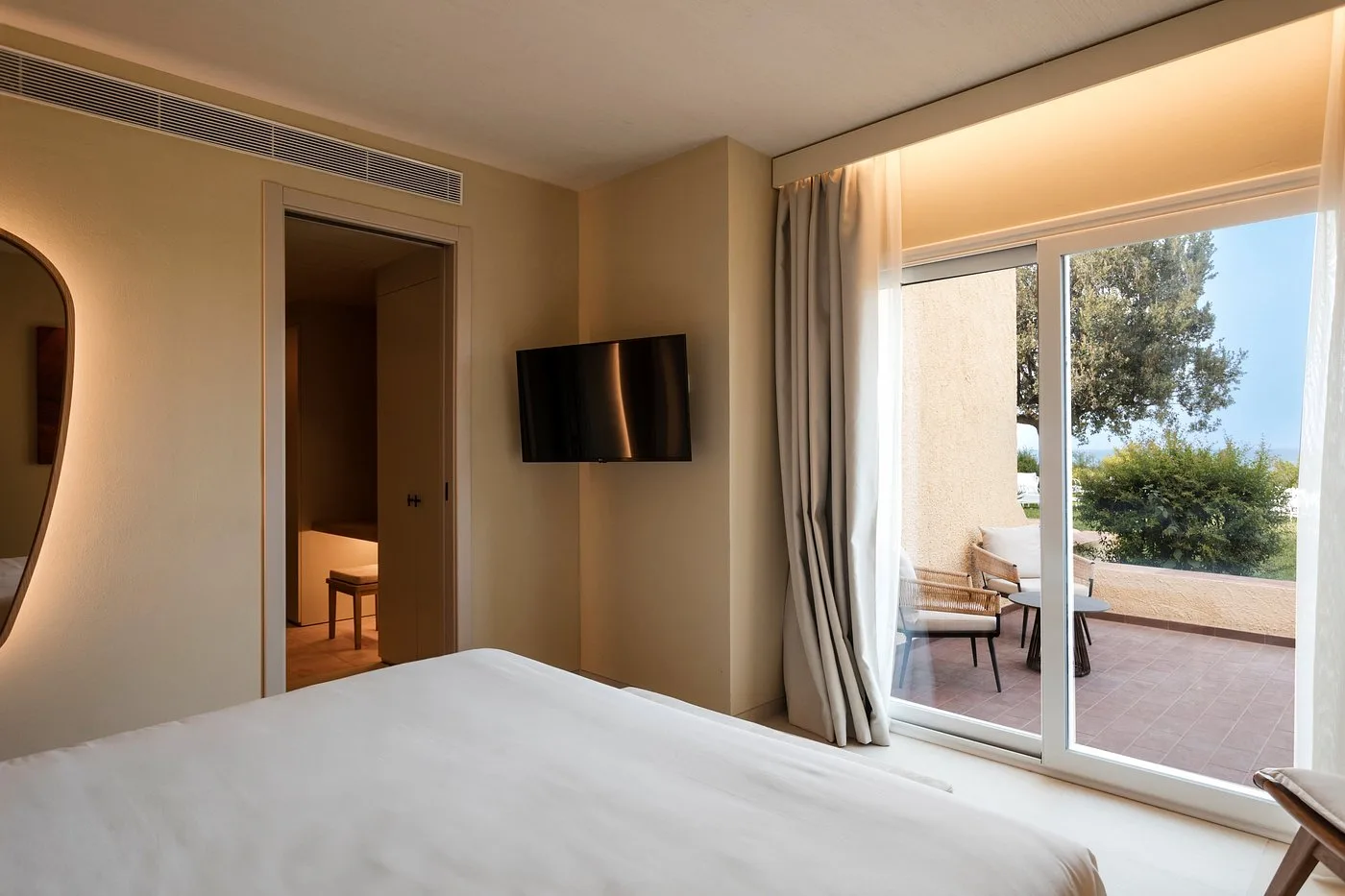 Camera moderna con letto matrimoniale e grande vetrata sul terrazzo