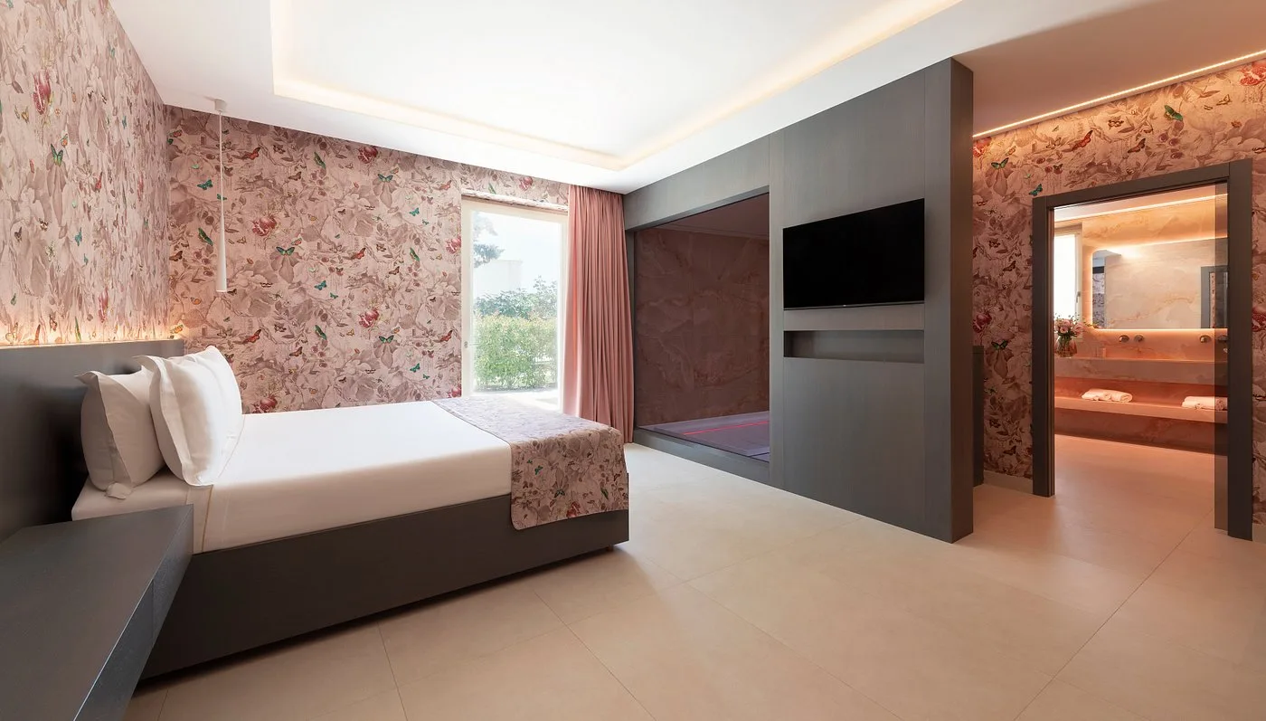 Suite moderna con carta da parati floreale rosa e bagno open space