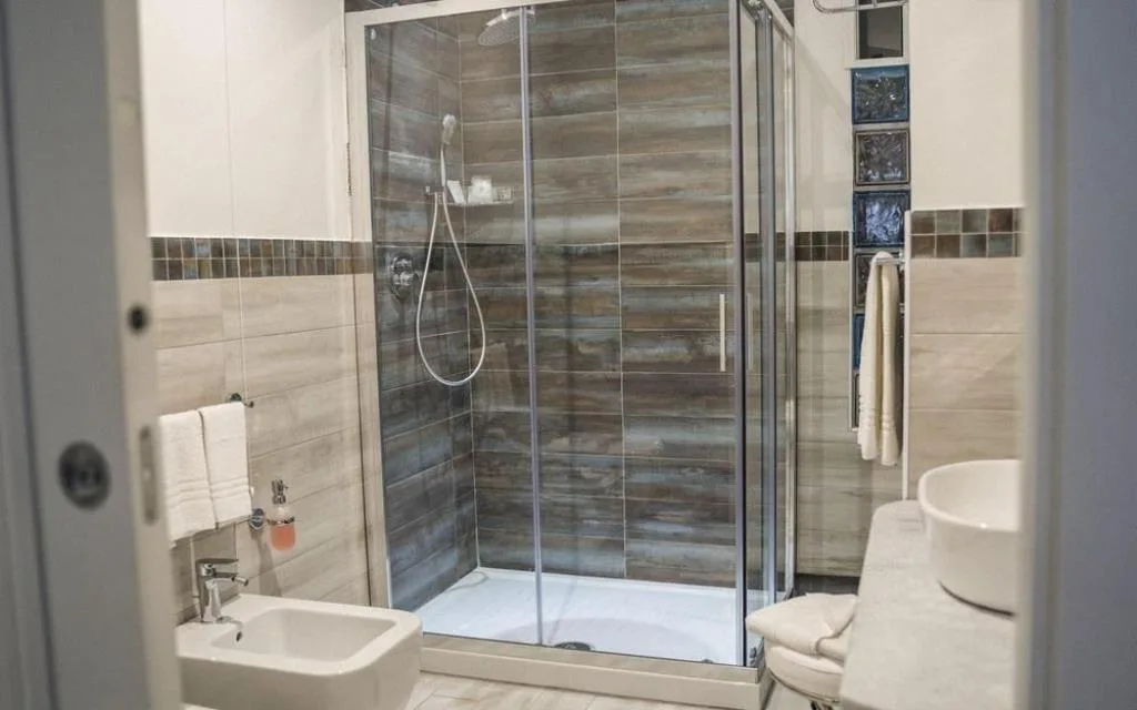 Bagno moderno con doccia, bidet e lavabo con piastrelle effetto legno