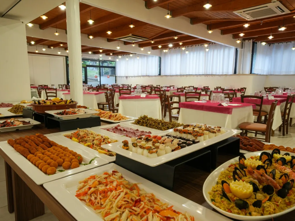 Buffet del ristorante con vassoi di antipasti, frittelle, frutti di mare e piatti tipici