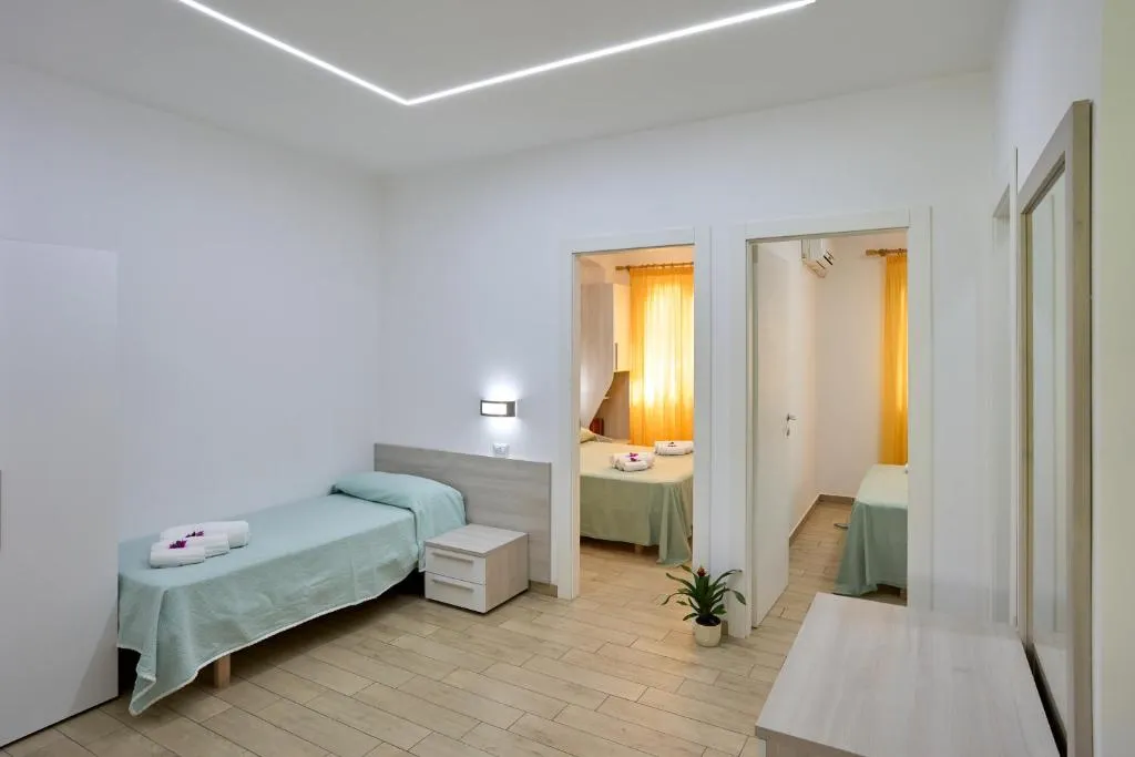 Camera con letto singolo e camere comunicanti dai toni chiari