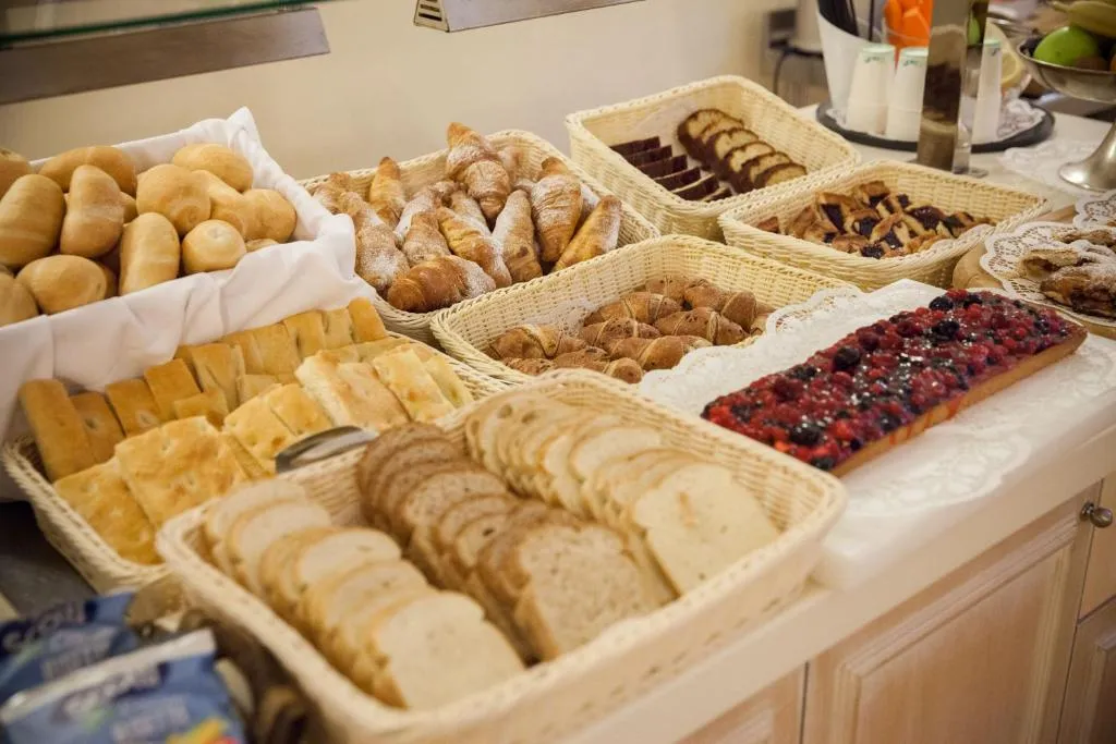 Buffet della colazione con cornetti, pane, dolci e crostata ai frutti di bosco