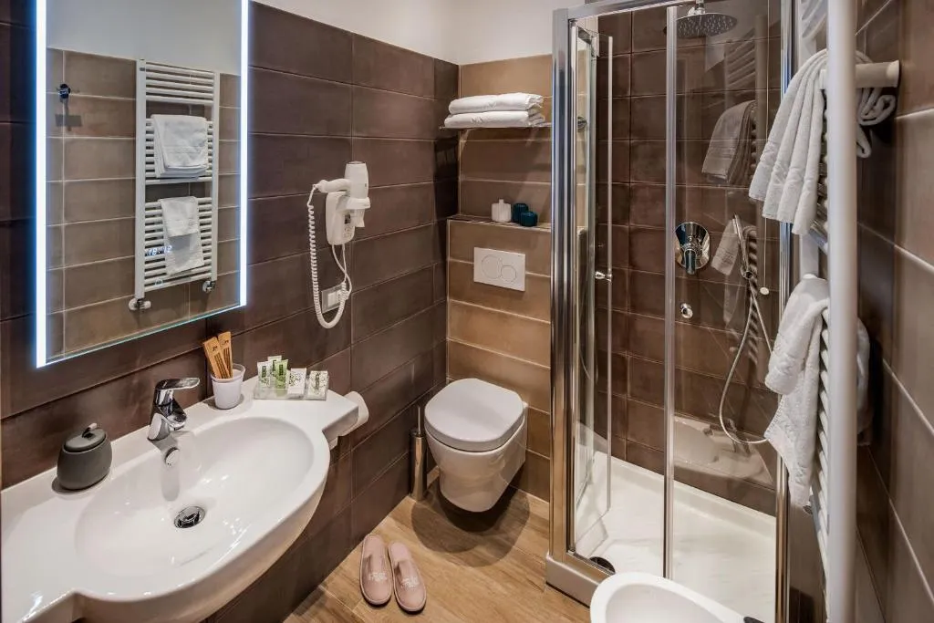 Bagno moderno con piastrelle marroni, doccia in vetro e lavabo bianco