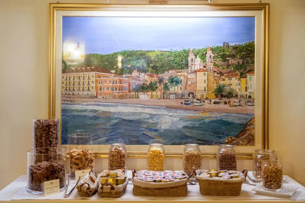 Buffet colazione con cereali, biscotti e yogurt sotto dipinto di paesaggio marino