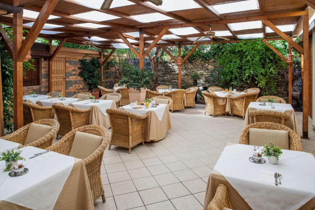 Terrazza esterna per la colazione con pergolato in legno e vegetazione