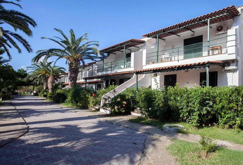 Vialetto del villaggio con edifici a due piani, balconi e palme