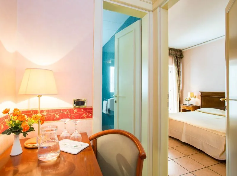 Interno di suite con angolo soggiorno, camera da letto e bagno