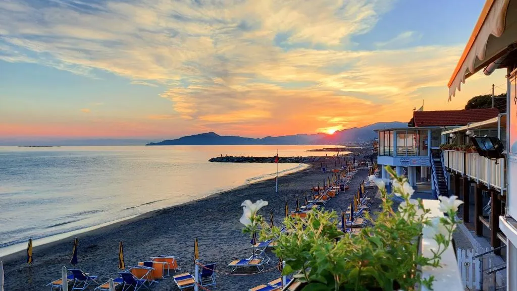Vista panoramica sulla spiaggia con lettini al tramonto sul mare