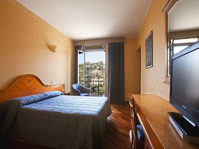 Camera matrimoniale con scrivania, TV e balcone con vista sulle colline