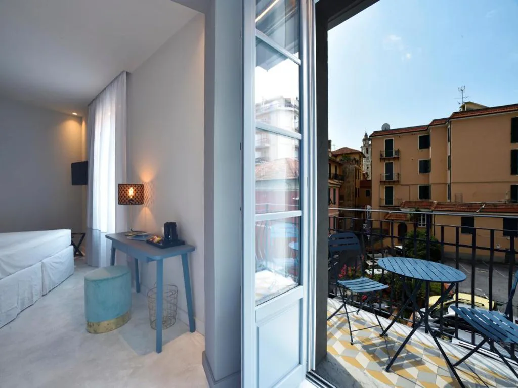 Camera con scrivania azzurra e balcone affacciato sui tetti del centro storico