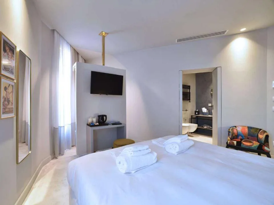 Camera matrimoniale con TV a parete e bagno en-suite con vasca