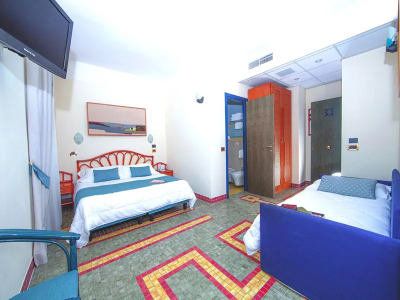 Camera familiare con letto matrimoniale e divano letto, bagno e pavimento a mosaico colorato