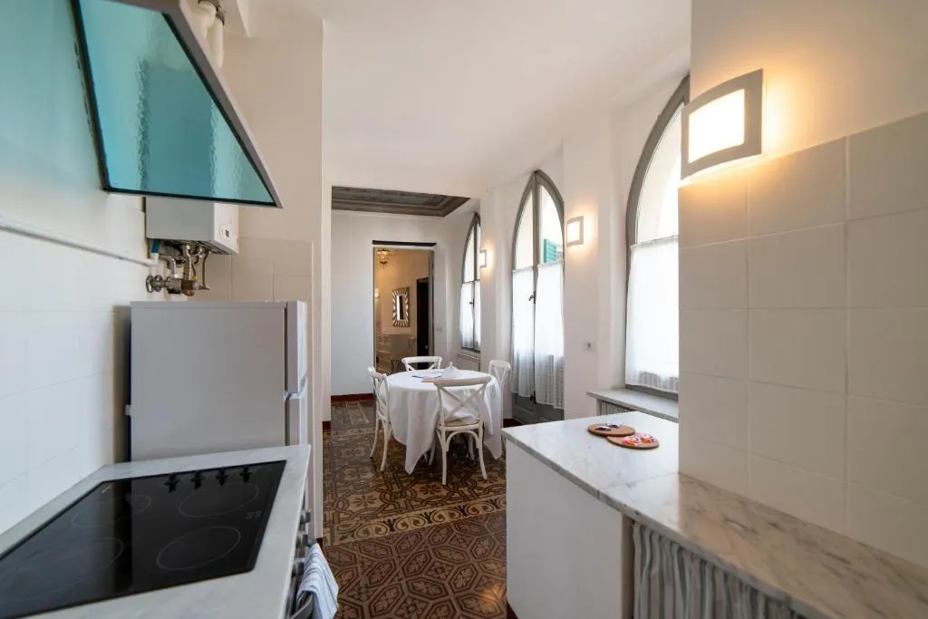 Cucina con angolo cottura e tavolo da pranzo in ambiente con finestre ad arco