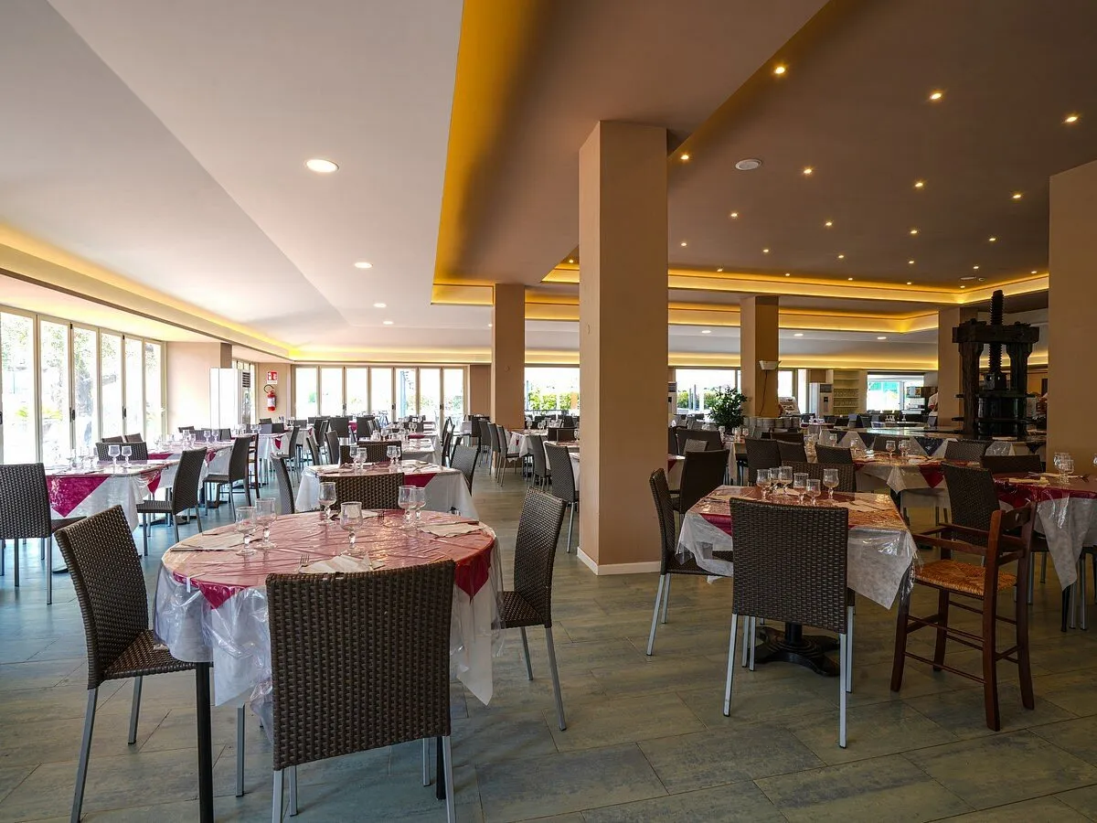 Sala ristorante interna con tavoli apparecchiati e illuminazione soffusa