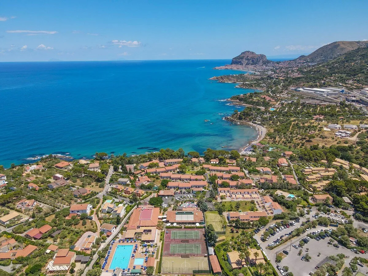 Veduta aerea del resort sulla costa di Cefalù con mare e rocca