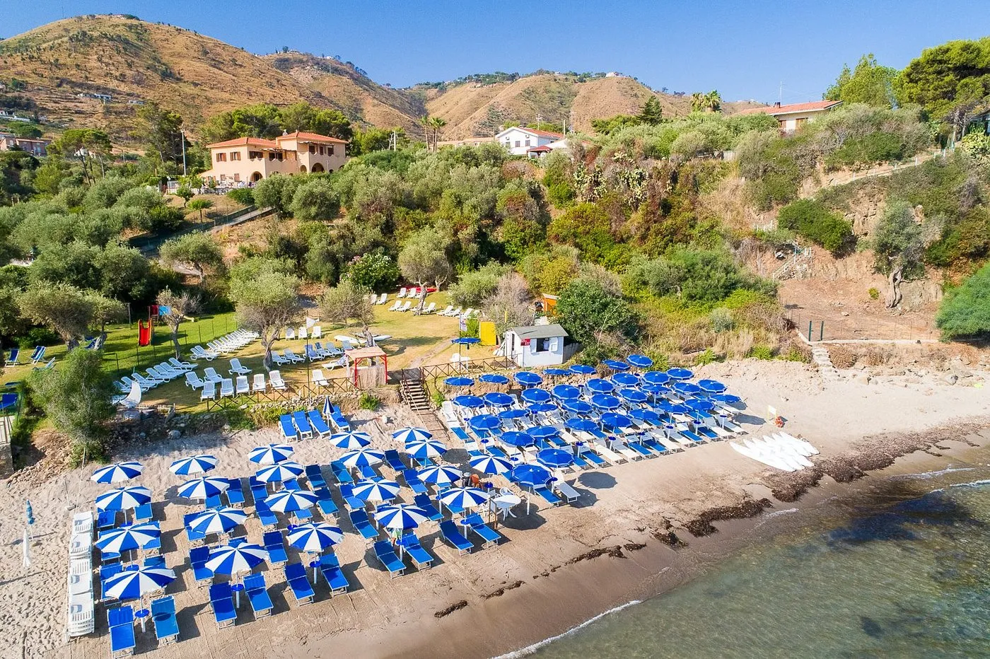 Veduta aerea della spiaggia attrezzata con ombrelloni blu e bianchi