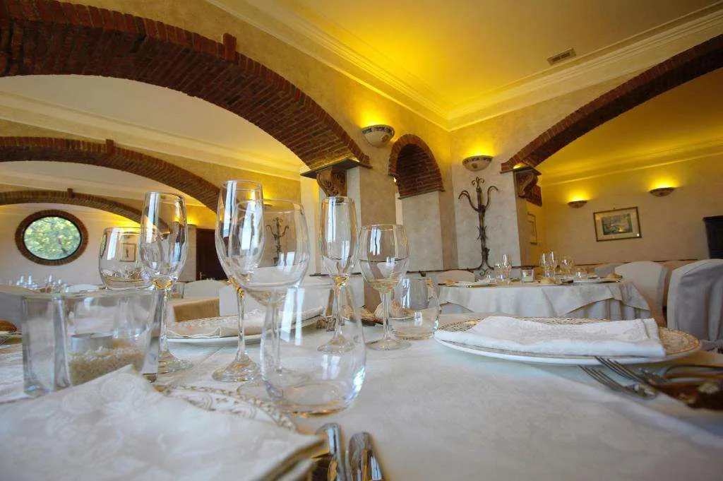 Sala ristorante elegante con soffitti a volta in mattoni e tavoli apparecchiati