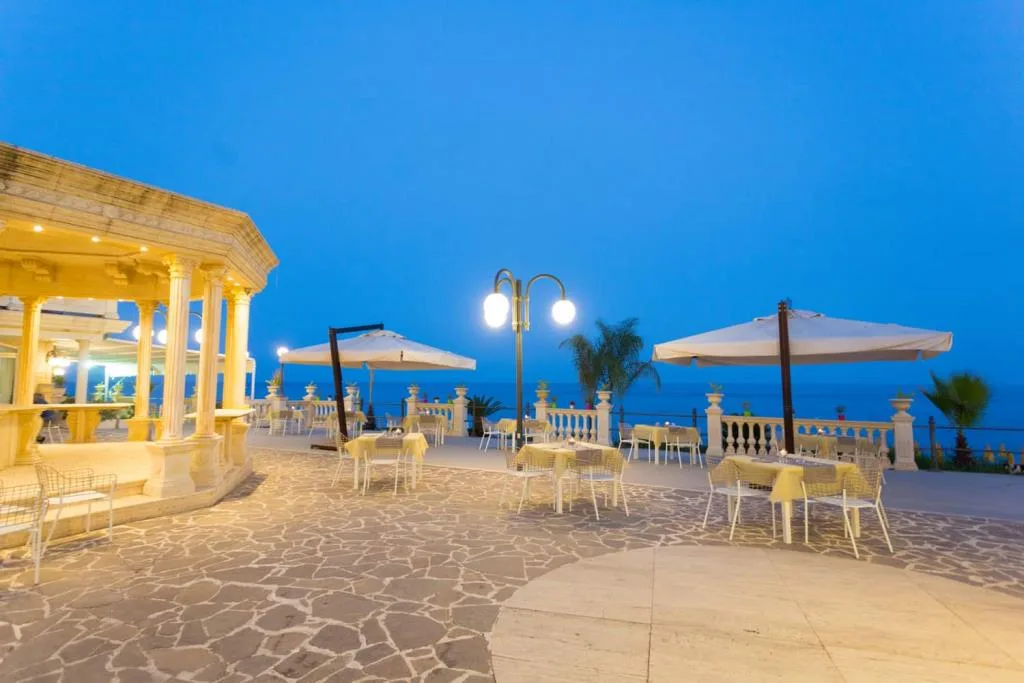 Terrazza esterna con tavoli e ombrelloni al crepuscolo