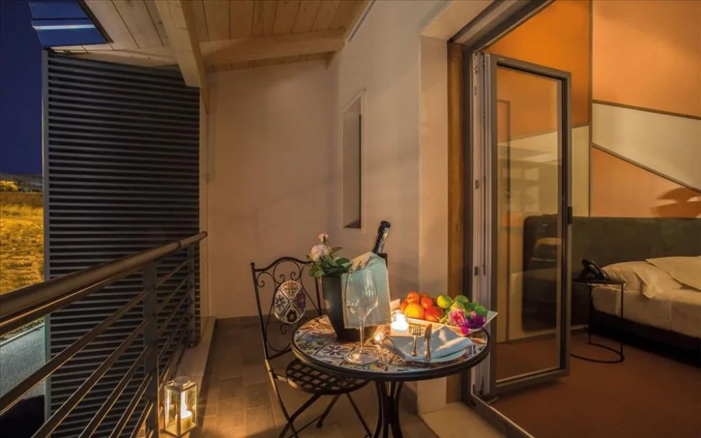 Balcone romantico allestito di sera con frutta, vino e vista sulla campagna
