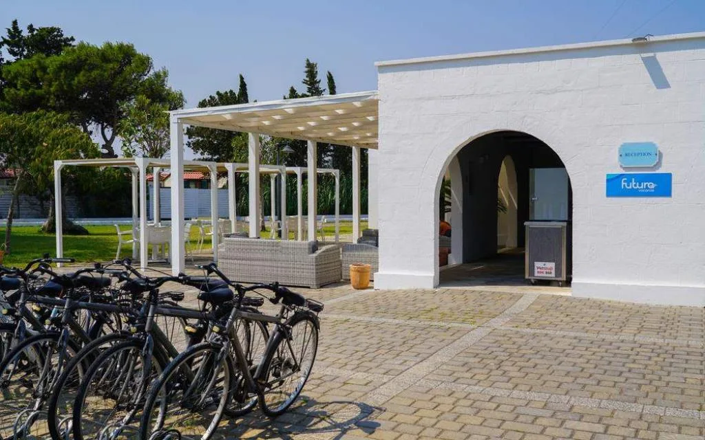 Ingresso reception con arco bianco, biciclette e area relax