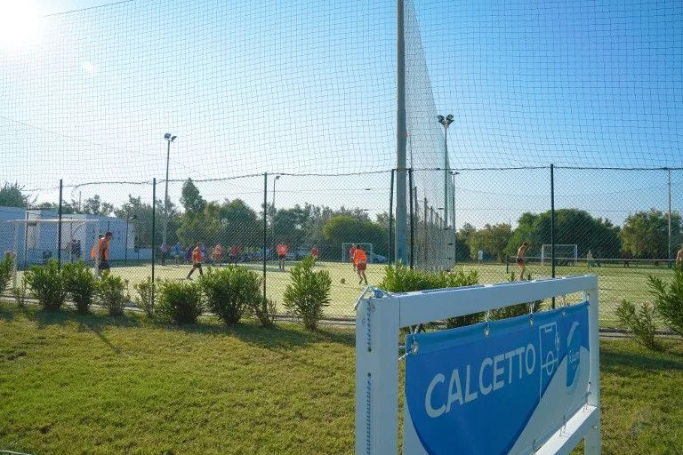 Campo da calcetto con giocatori e insegna Calcetto