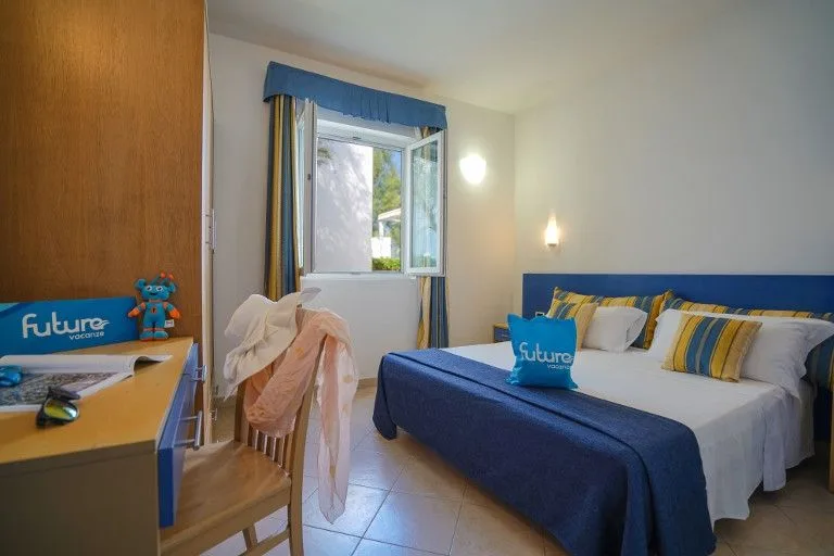 Camera con letto matrimoniale, scrivania e finestra sul giardino