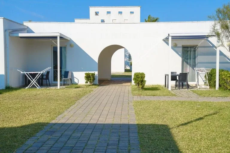 Bungalow bianchi con arco, verande e giardino