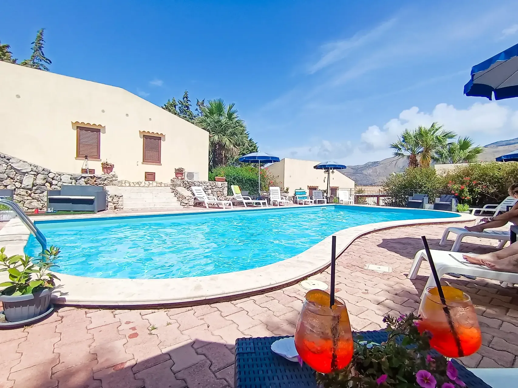Piscina con aperitivi in primo piano e vista sulle montagne