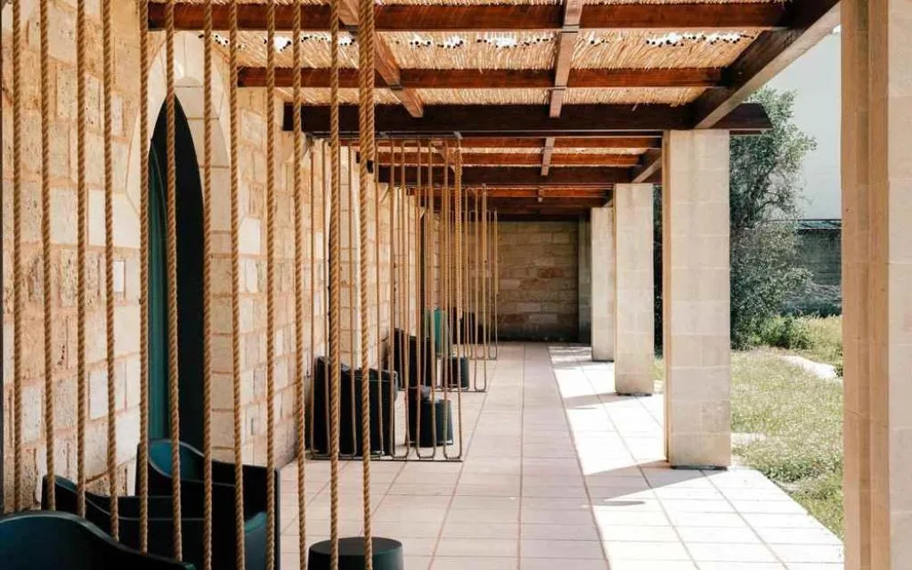 Porticato in pietra con travi in legno e decorazioni in corda