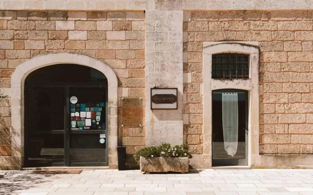 Ingresso del ristorante con facciata in pietra e insegna