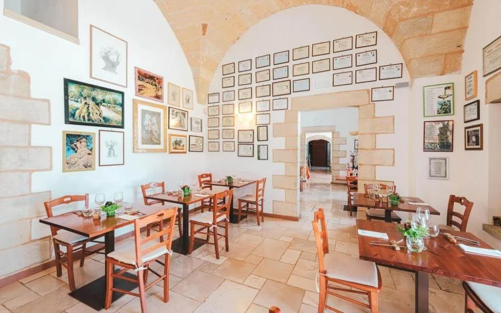 Sala interna del ristorante con volte in pietra e tavoli in legno