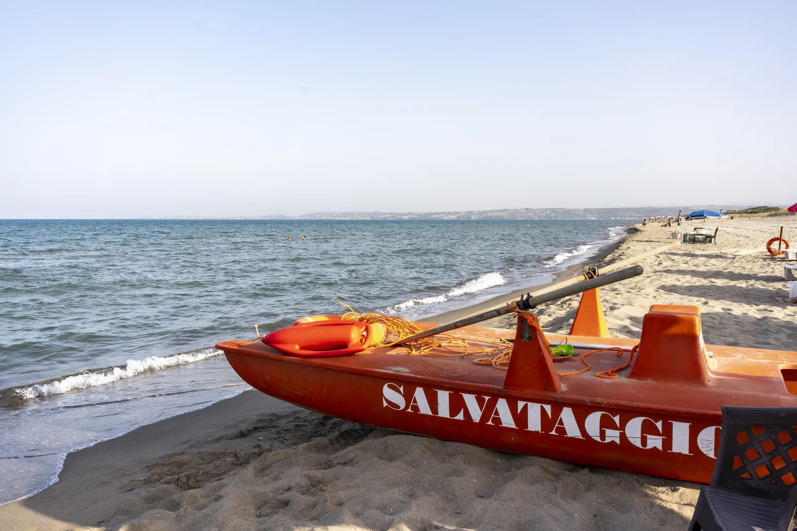 Spiaggia con pattino di salvataggio arancione in riva al mare