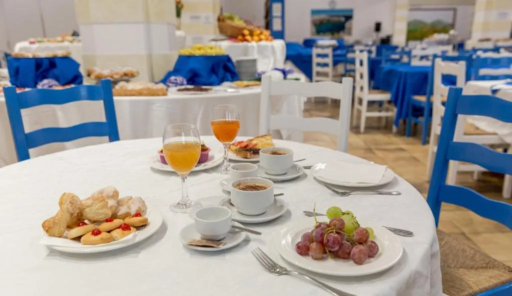 Tavolo apparecchiato con colazione a buffet, dolci, frutta e bevande