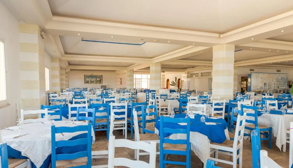 Sala ristorante interna con tavoli e sedie bianche e blu in stile mediterraneo